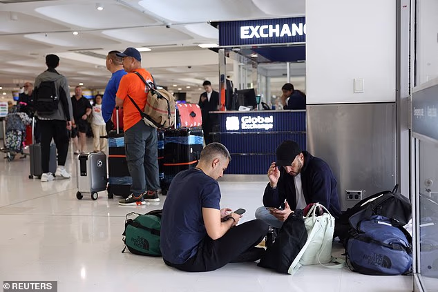 Dozens of flights from Australia have been cancelled this week due to the escalating conflict in the Middle East. Pictured are stranded travellers at Sydney Airport 